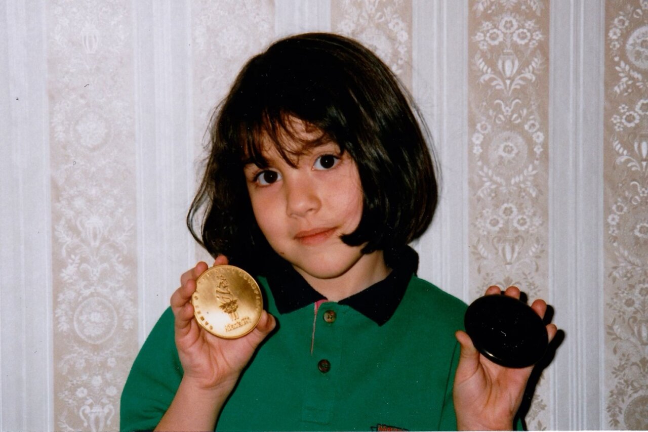 A young Melissa Humana-Peredes shows off her father's Olympic Bronze medal from the 1996 Atlanta Games.